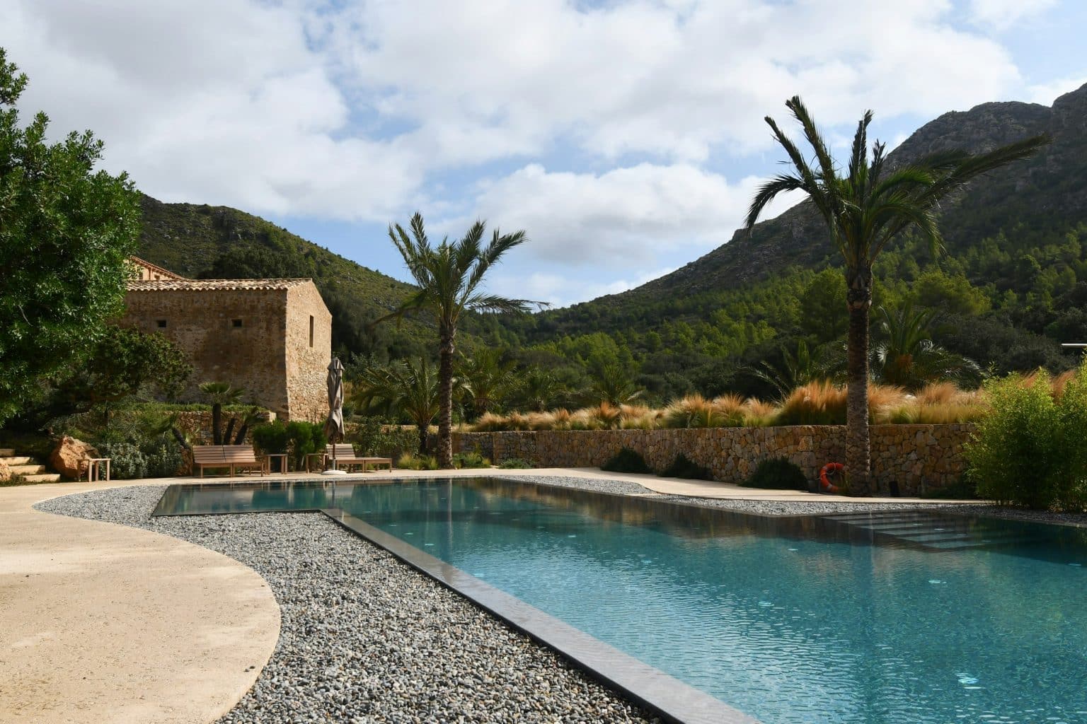 Restored stone finca with a pool, palm trees and mountains, Mediterranean countryside